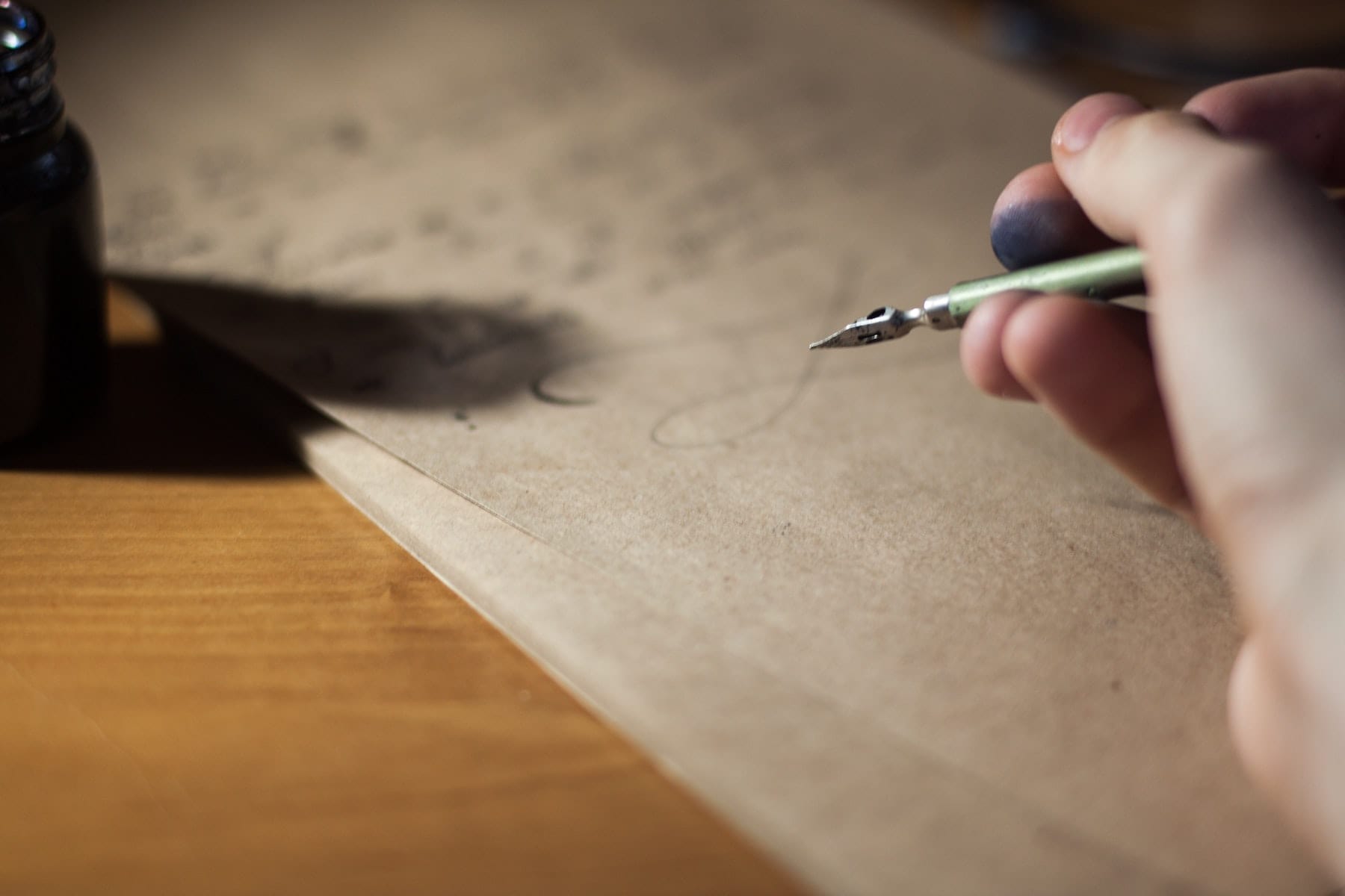 Nahaufnahmer einer Hand mit einem Füllerpfederhalter auf einem Blatt Papier